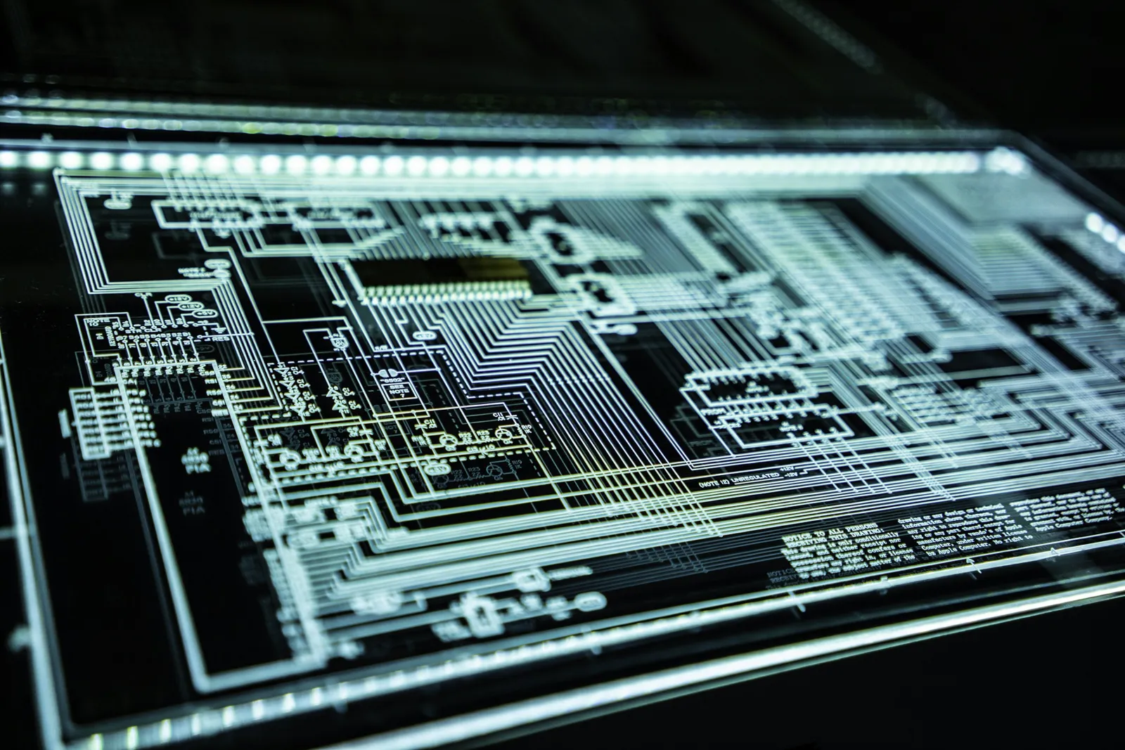 A glowing blue circuit board pattern on a dark background.