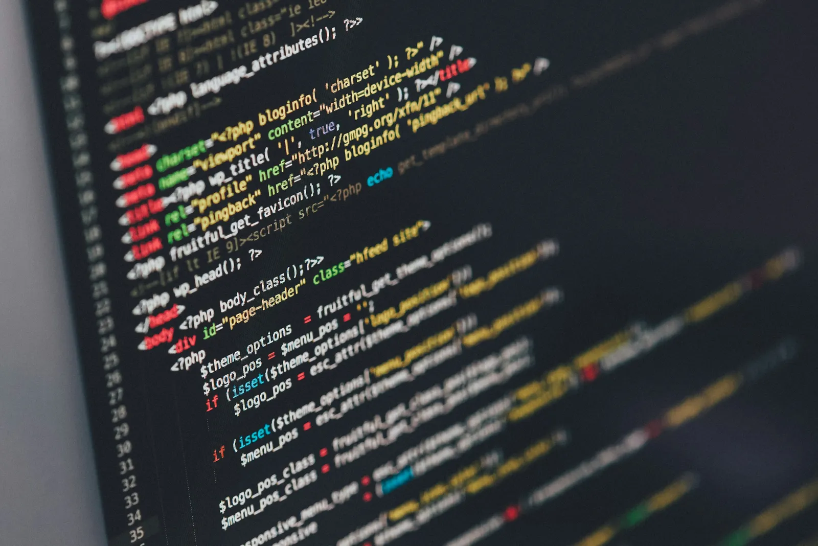Close-up of colourful code on a dark screen.